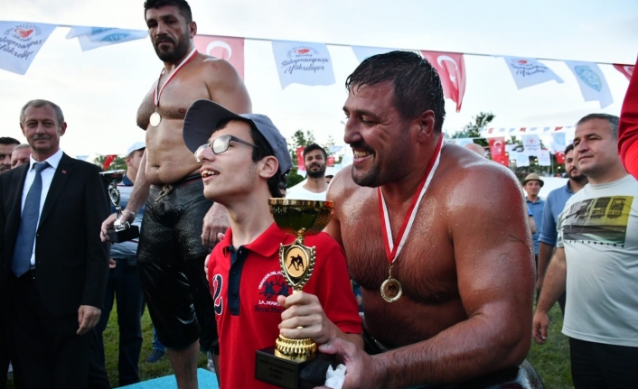 Yağlı güreşlerin şampiyonu, kupasını engelli gence hediye etti